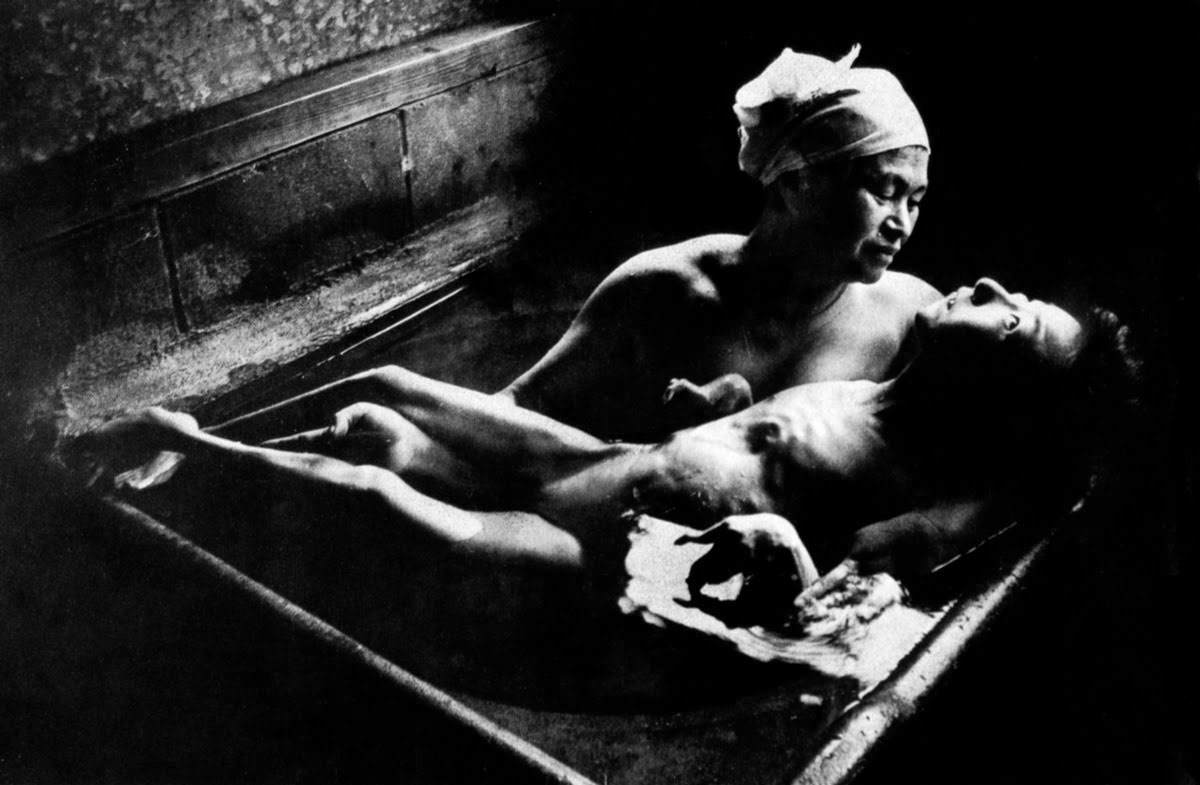 W. Eugene Smith: „Tomoko vonioje su savo motina”. Minamata, 1971. Mergaitė sunkiai serga ir jos motina turi būti vonioje kartu su ja, kad ją nuprausti.