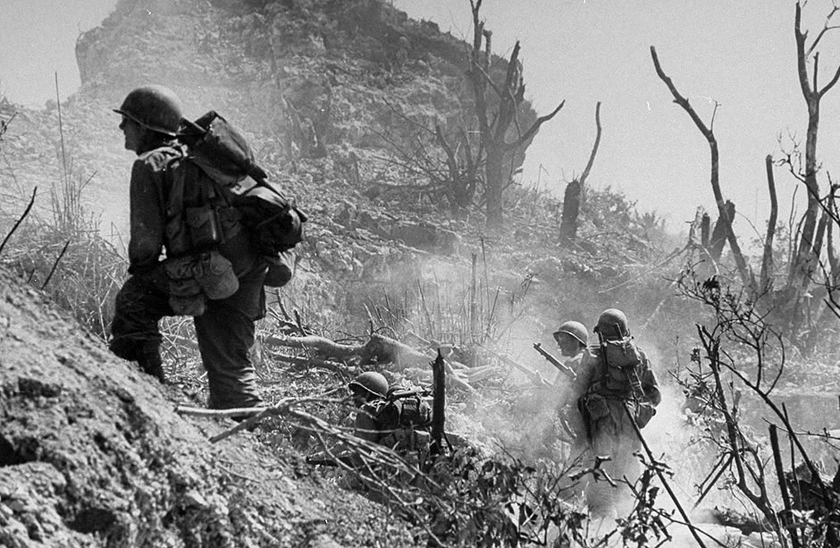 W. Eugene Smith „Amerikos 7-os divizijos pėstininkas atsargiai renkasi kelią per pabūklų dūmuose skendintį plotą“. Okinava, 1944